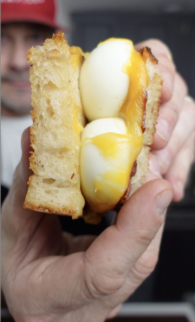 Tim holding up a deviled egg sanwhich.